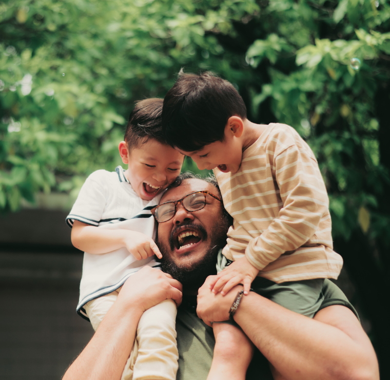 Happy Dad Carrying His Two Little Sons on His Shoulders