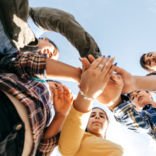 people with hands in a huddle