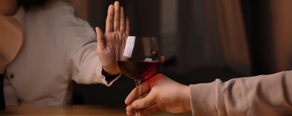 person with hand in front of glass of wine
