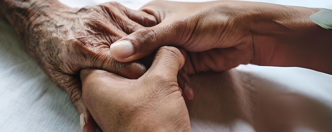 young hands holding elderly person's hand