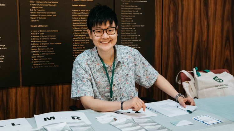 person smiling behind desk with name tags