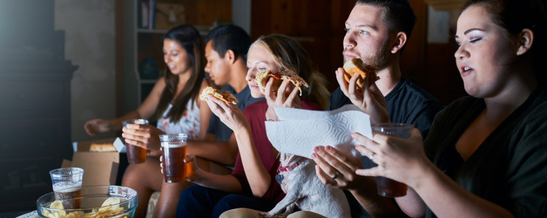 group of people eating and watching tv