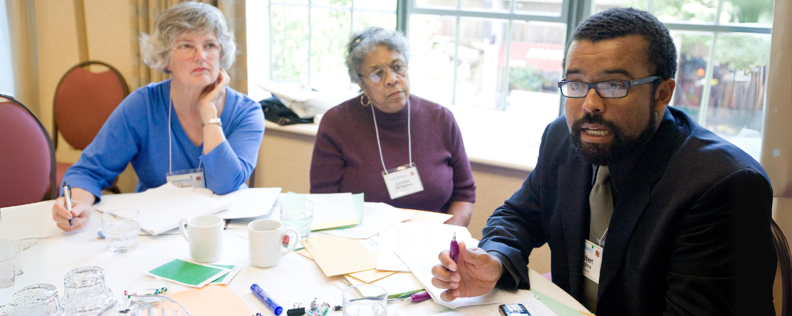 people at table speaking to one another