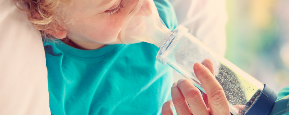 person helping child use nebulizer