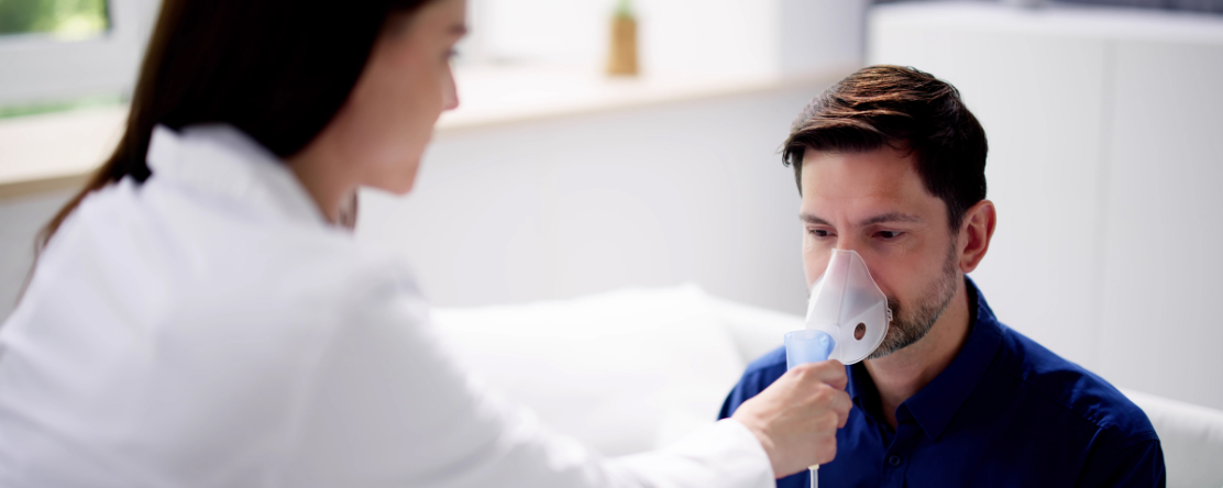 woman assisting man with nebulizer