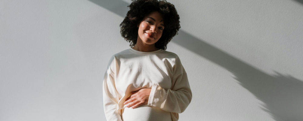 African American woman who's pregnant and holding her stomach