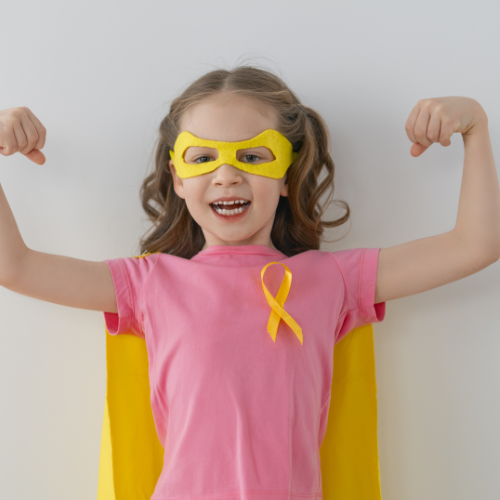 child wearing superhero costume and cancer ribbon