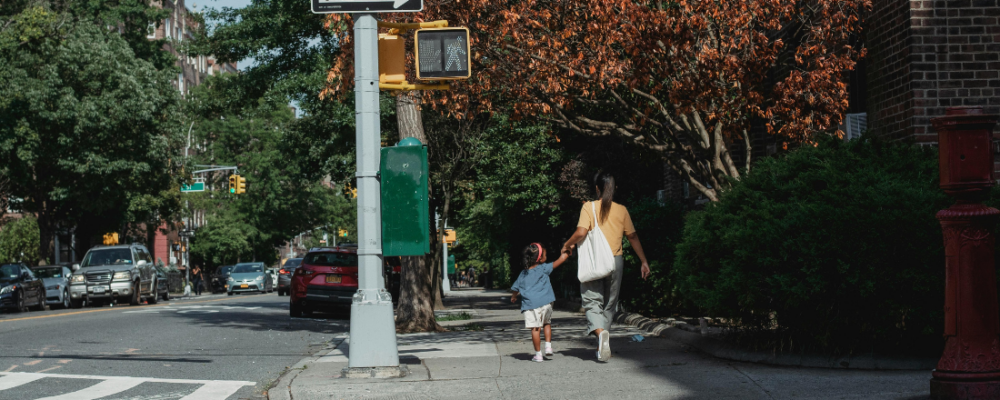 woman walking with child across the street