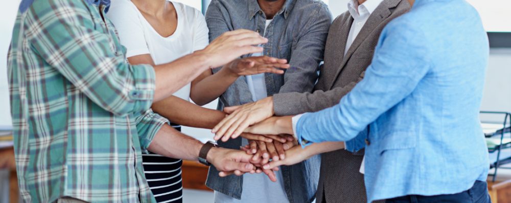 group of people with hands in huddle