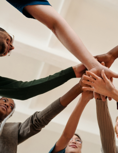 people with hands in a huddle