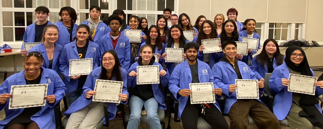 Faces cohort group photo holding certificates