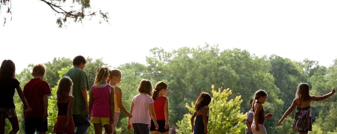 children walking outside with trees in background