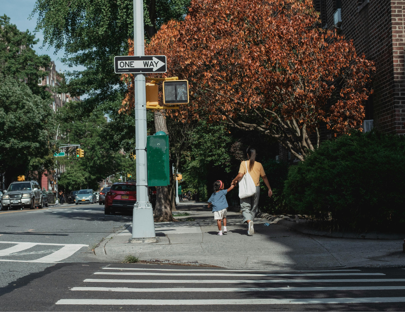 woman walking across the street with child