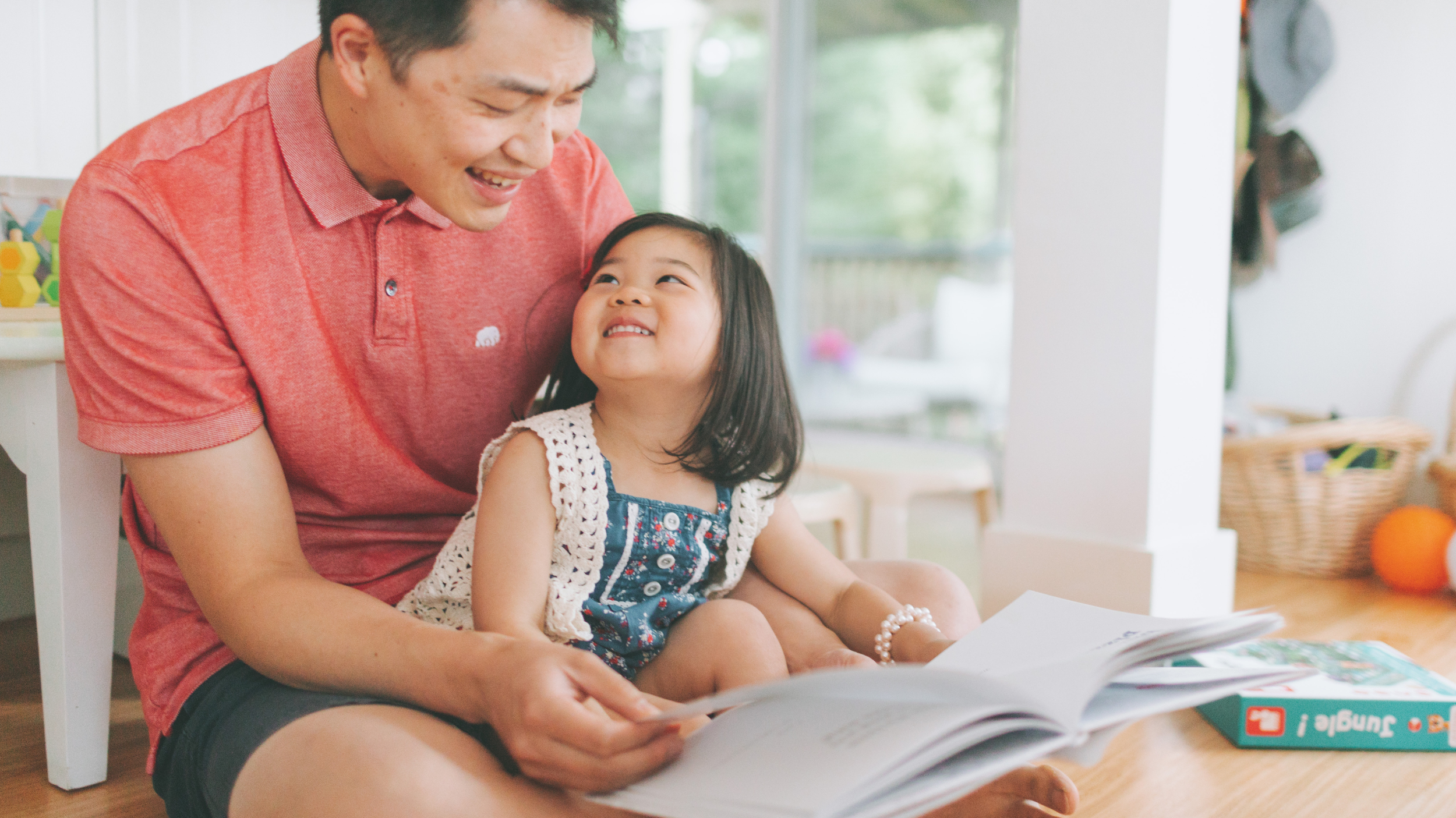 Father reading to daughter at home