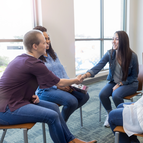 people holding hands in recovery group